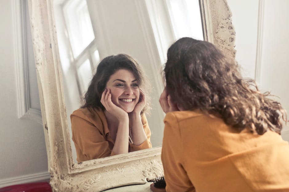 Woman smiling at herself in the mirror