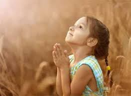 Little girl looking to heaven while she prays