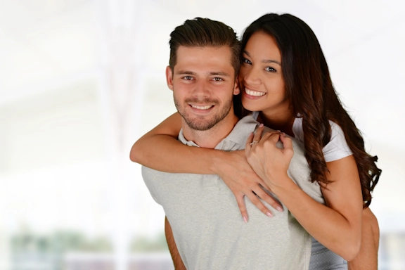 A happy couple smile as they hug each other